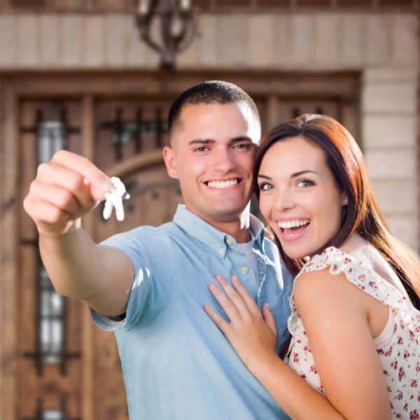 A happy couple holding the keys to their new home.